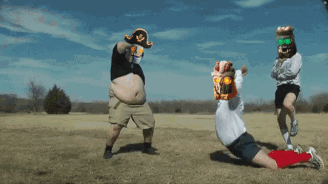 a man wearing a pirate hat is pushing another man on a field