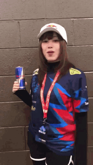 a woman wearing a red bull shirt is holding a red bull can