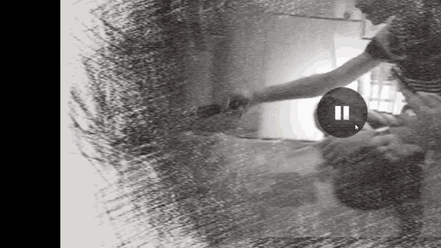 a black and white photo of a person taking a selfie with a pause button