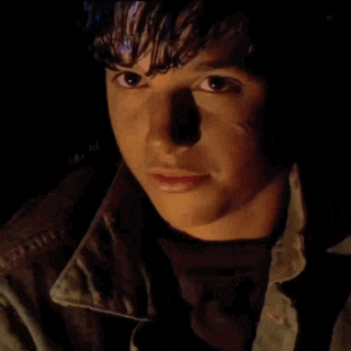 a close up of a young man 's face with a shadow on his face