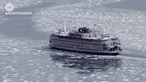 a boat is floating on top of a body of water with a city in the background .