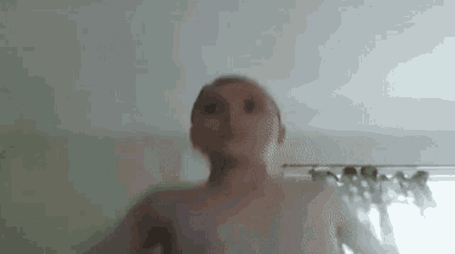 a man without a shirt is taking a selfie in a room .