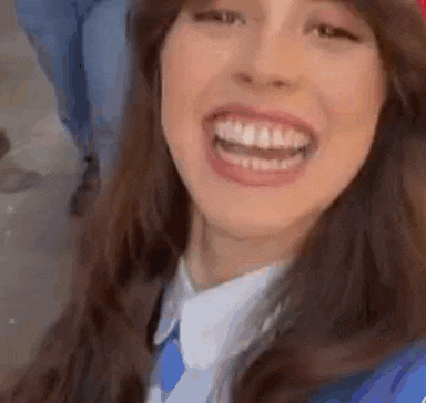 a close up of a woman 's face with her mouth open and her teeth showing .