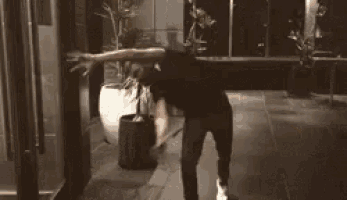 a man is dancing in front of a refrigerator in a dark room .
