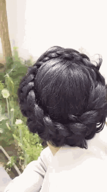 a close up of a person 's head with a braided hairstyle .