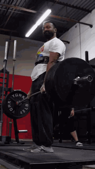 a man is lifting a barbell with a york weight plate on it