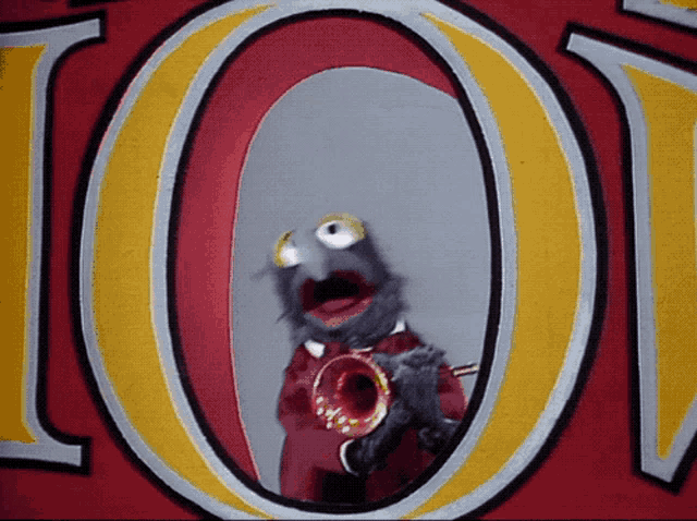 a muppet playing a trumpet in front of a large o
