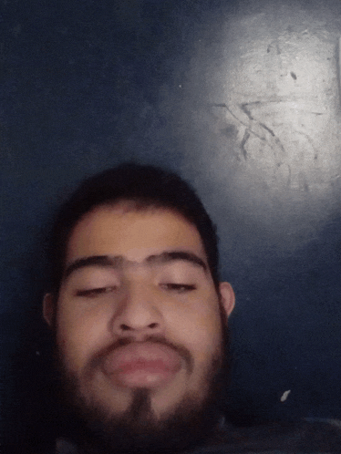 a man with a beard is making a funny face