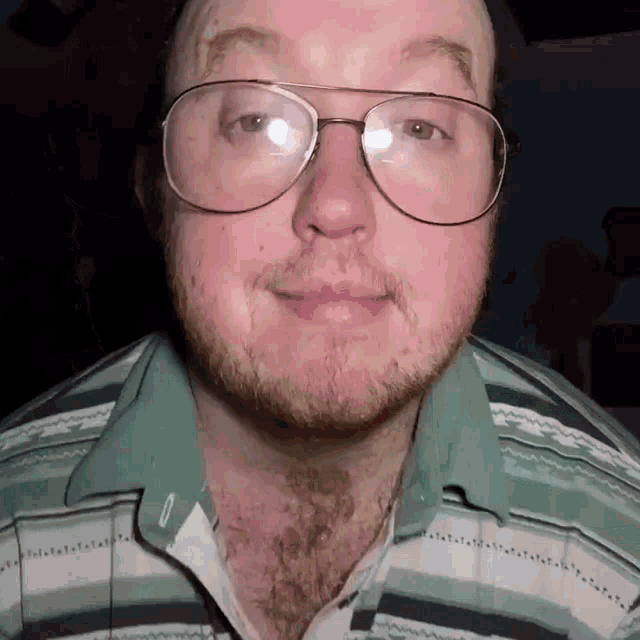 a man with glasses and a beard is wearing a striped shirt