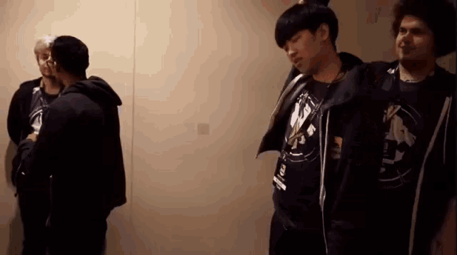 a group of men are standing in a room and one of them is wearing a shirt that says ' lg '