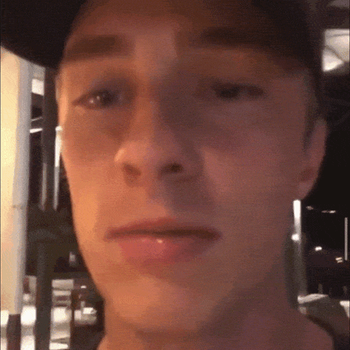 a close up of a man 's face wearing a baseball cap