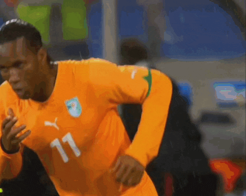 a soccer player in an orange jersey with the number 11 on it