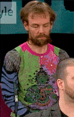 a man with a beard is wearing a colorful shirt with a picture of a monkey on it