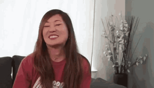 a woman is smiling while sitting on a couch in a living room .