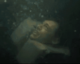 a man is swimming in the water with a life preserver on his neck .