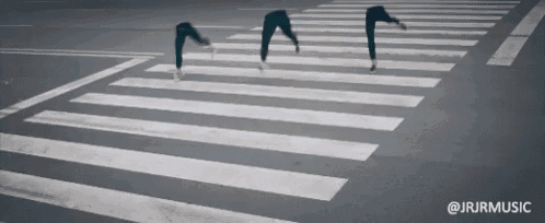 a person crossing a crosswalk with the hashtag @jrjrmusic in the corner