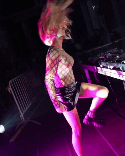 a woman dancing in front of a pioneer dj