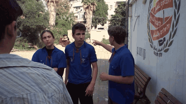 a group of people are standing in front of a wall that has a logo on it