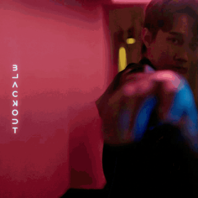 a man stands in front of a sign that says blackout on it