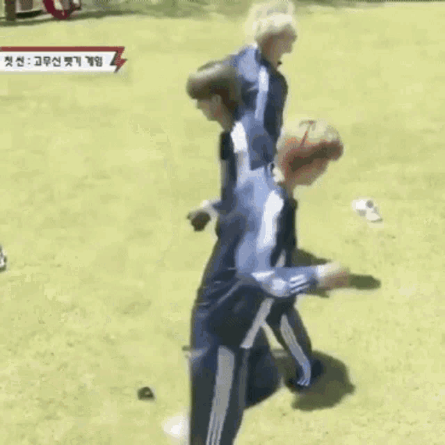 a group of people are playing soccer on a field with chinese writing on the screen .