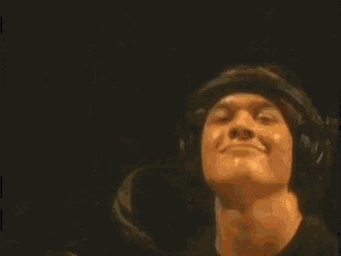 a woman is putting headphones on a man 's head while they are on a stage .