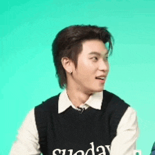 a young man wearing a black vest that says sunday on it