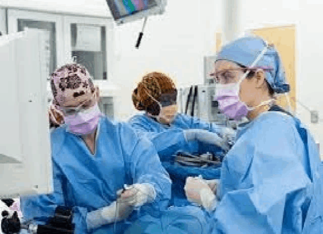 a group of surgeons are operating on a patient in a hospital operating room .