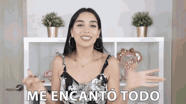 a woman says me encanto todo in front of a white shelf