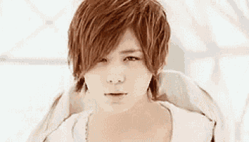 a close up of a young man 's face with red hair and a white shirt .