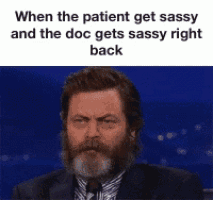 a man with a beard is wearing a suit and tie and is talking into a microphone .