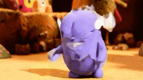 a purple stuffed animal is standing on the floor in a room .