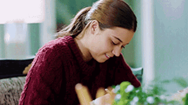 a woman in a red sweater is sitting at a table