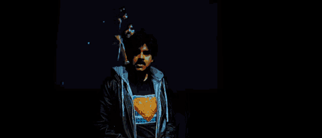 a man wearing a superman t-shirt is standing in the dark