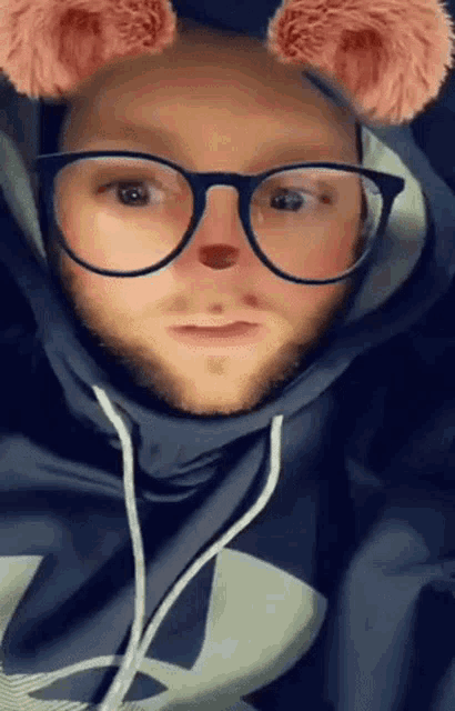 a man wearing glasses and a hooded sweatshirt with the letter l on it