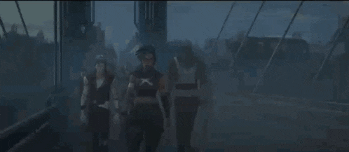 a group of people are standing next to each other in a dark room and talking to each other .