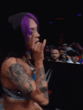 a woman with purple hair has a tattoo on her arm that says ' i love you '