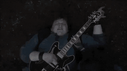 a person laying on the ground playing a guitar