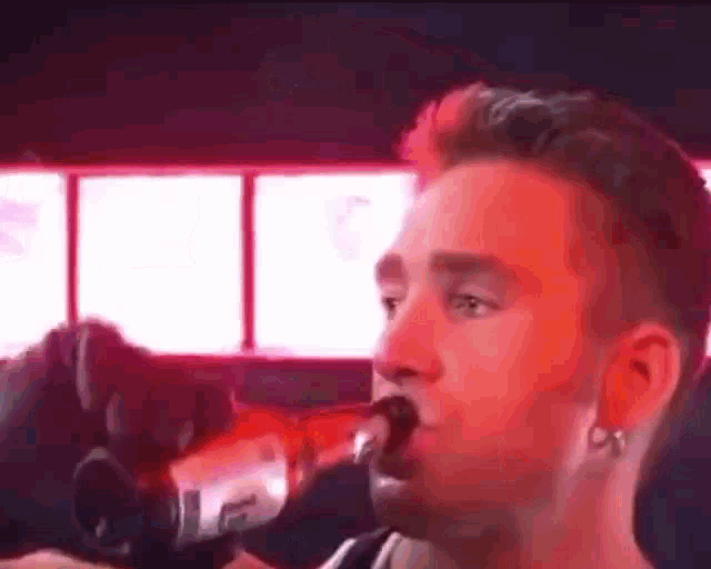 a man singing into a microphone in a dark room