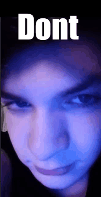 a close up of a person 's face with a blue background and the words `` dont '' written on it .
