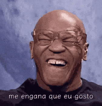 a bald man wearing glasses is laughing with the words me engana que eu gosto above him