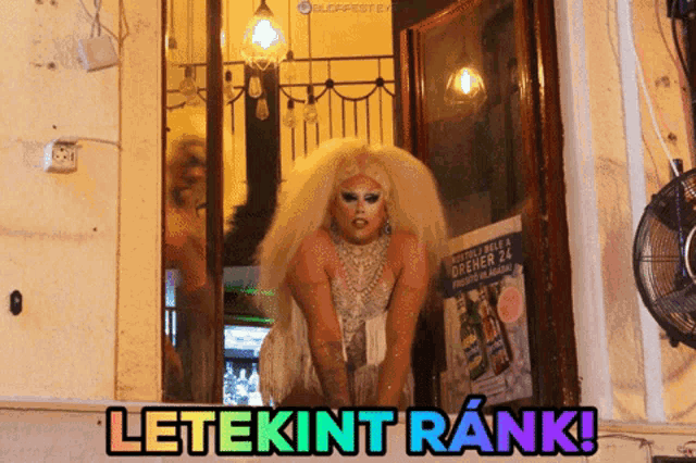 a drag queen stands in front of a sign that says dreher 24 on it