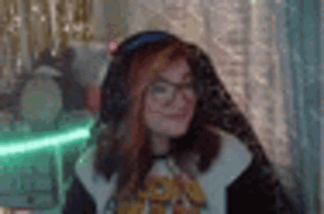 a woman wearing glasses and headphones is sitting in front of a computer .