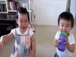 a little girl and a little boy drinking from a purple water bottle