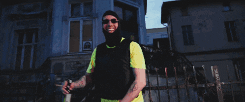 a man wearing sunglasses and a ski mask points his finger at the camera