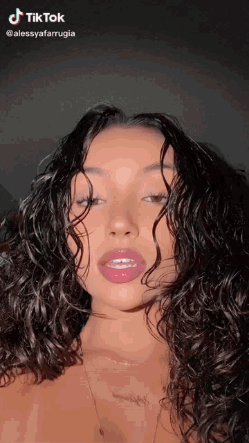a woman with curly hair has a tiktok icon on her face