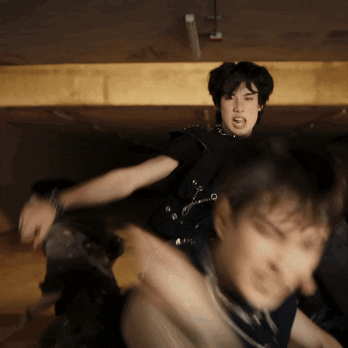 a man in a black shirt is yelling at another man in a black shirt
