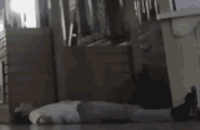 a person is laying on the floor in a room with a speech bubble above them .