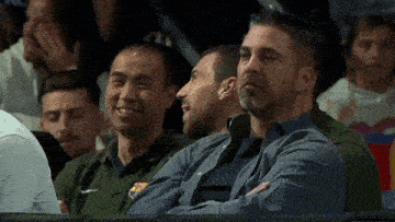a group of men sitting in a stadium watching a game