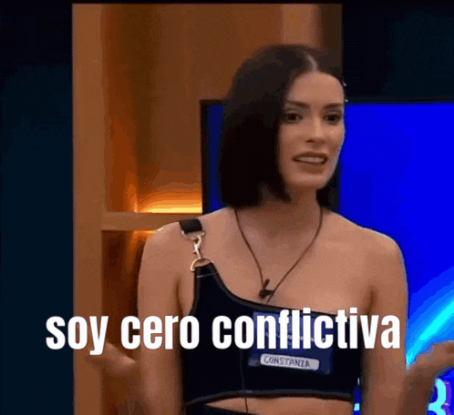a woman in a black crop top is standing in front of a television and says soy cero conflictiva