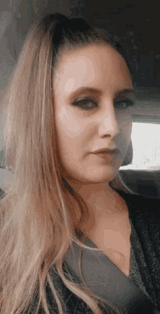 a close up of a woman 's face in a car with a ponytail .